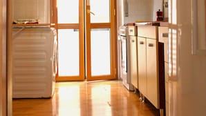 Une cuisine avec des meubles en bois, un réfrigérateur et un lave-linge.