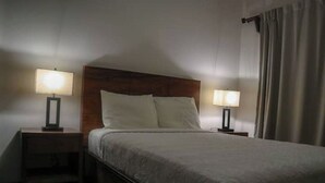 A hotel room with a large bed, two bedside tables with lamps, and a wooden headboard. - Private house with pool, near Tamarindo. (Provincia de Guanacaste)