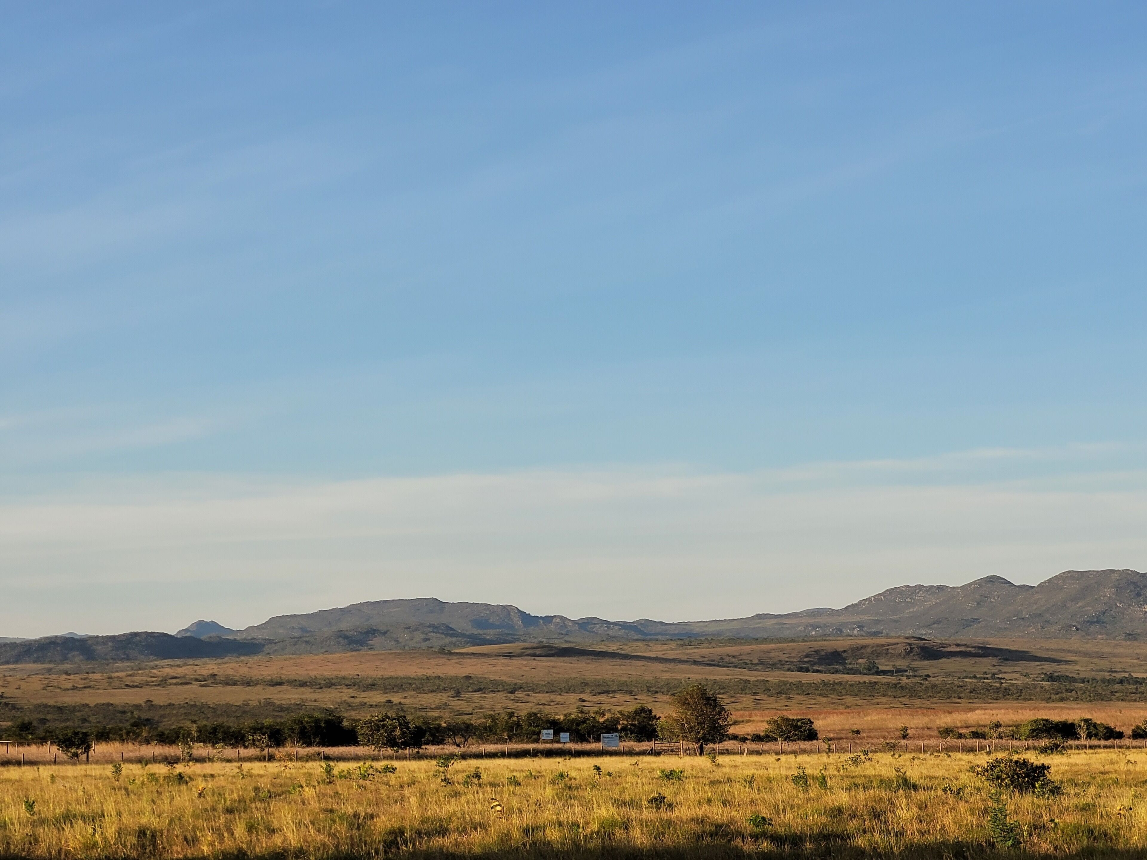 A flat landscape with distant mountains and a clear sky.