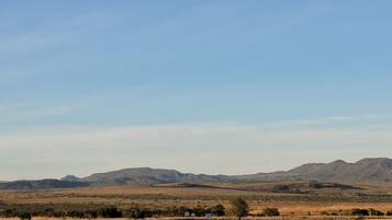 A flat landscape with distant mountains and a clear sky.