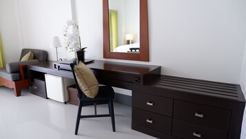 A modern hotel room with a desk, chair, and a large mirror.