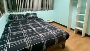 Une chambre à coucher avec un lit, une armoire et une fenêtre avec des stores.