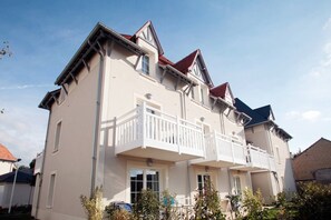 A two-story building with a balcony on the second floor. - Apartment in Cabourg near Beaches (Cabourg)