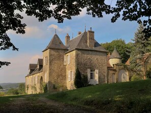 A stone building with a tower, arched windows, and a dome.
