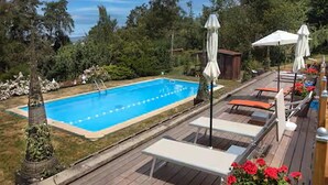 A swimming pool with lounge chairs and umbrellas, surrounded by greenery. - Cosy Castle with Pool in Onlay (Onlay)