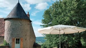 A stone tower with a conical roof, a door with shutters, and a small staircase leading up to it. - Cosy Castle with Pool in Onlay (Onlay)