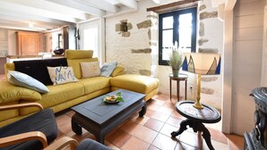 Una sala de estar con un sofá amarillo, una mesa de centro y una chimenea.