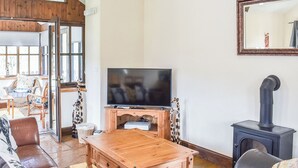 Un salon équipé d’un téléviseur, de meubles en bois, d’un canapé et d’une cheminée.