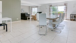 A spacious living area with a dining table, chairs, a sofa, and a coffee table. - Spacious villa with pool in Le Canet (Soleil d'Oc (Pouzols Minervois))