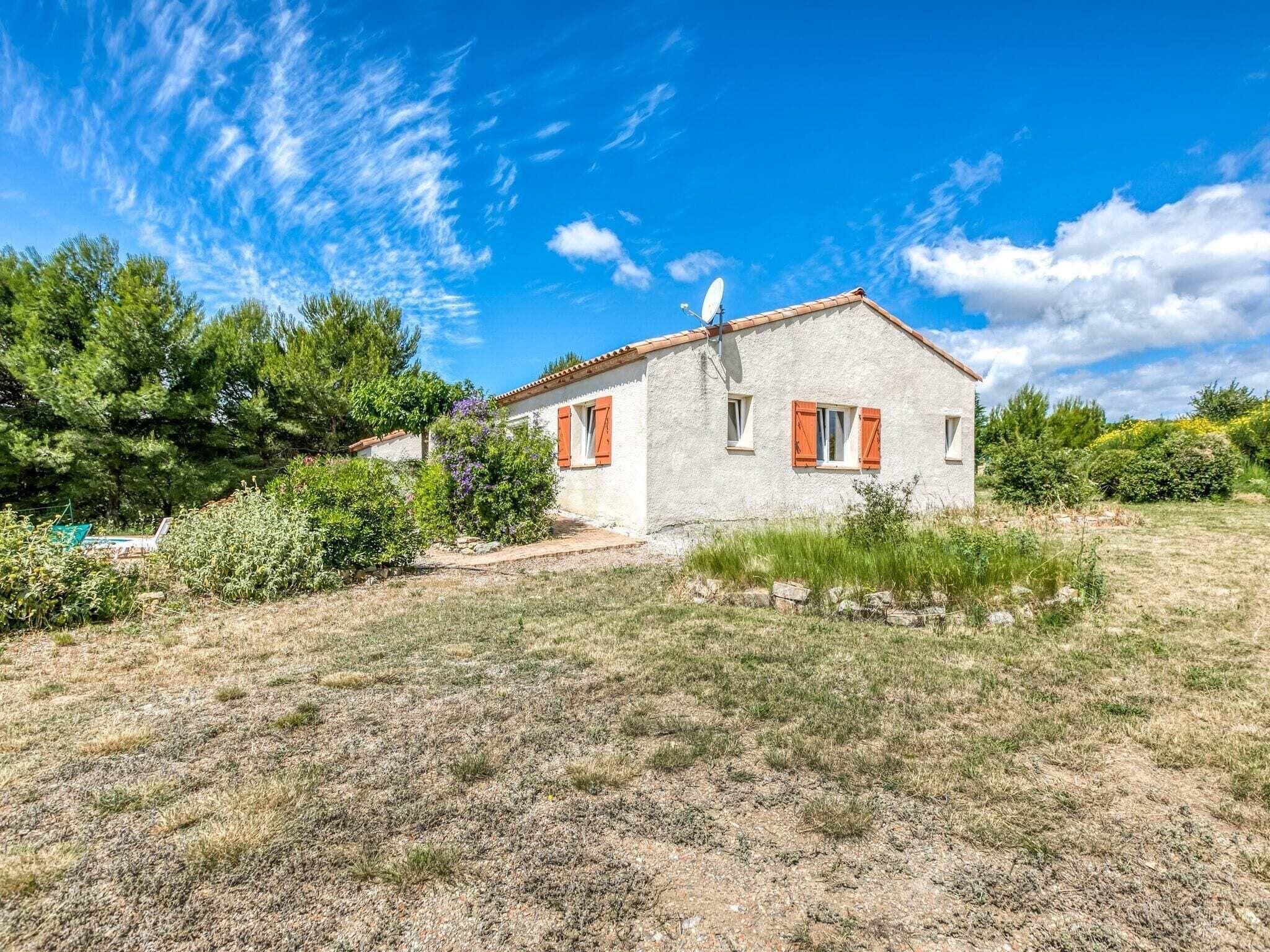 Una casa de planta baixa amb teulada inclinada i una antena parabòlica.
