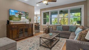 A living room with a sofa, coffee table, and a television on a cabinet.