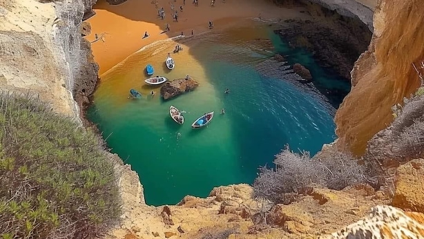 A coastal landscape with a large cave opening, a sandy beach, and clear blue waters. - Stunning views, private position - 5 mins to beach!  Heated pool option & Aircon (Budens)