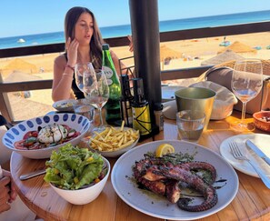 Un tavolo con cibo e bevande, con vista sulla spiaggia.