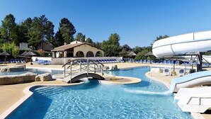 En swimmingpool med en bro, liggestole og en vandrutsjeban.