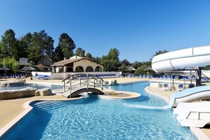 A swimming pool with a bridge, lounge chairs, and a water slide. - Apartment in Hilltop Setting (Vallon Pont D'arc)