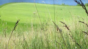 A golf course with a lake in the background. - Cozy Garden Retreat Malemort (Malemort)