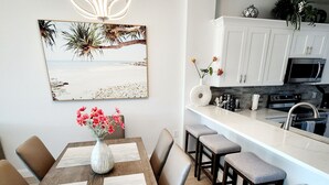 Une cuisine moderne avec des meubles blancs, un four à micro-ondes et un évier.