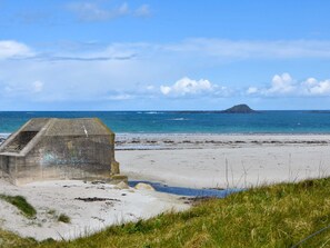 A concrete structure on a beach with a view of the sea and a distant island. - Atmospheric Breton house with garden (Ploudalmezeau)