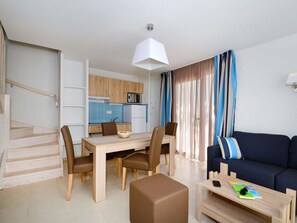 Uma sala de estar moderna com sofá, mesa de centro e área de jantar.
