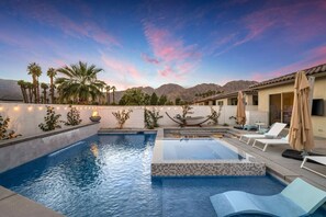 A pool area with lounge chairs and a hammock, surrounded by palm trees and a mountainous backdrop. - New! (PGA Signature) Platinum Magic! w/Gameroom! (La Quinta)
