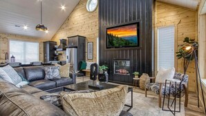 Un saló confortable amb una llar de foc, una televisió i un joc de sofà modern.