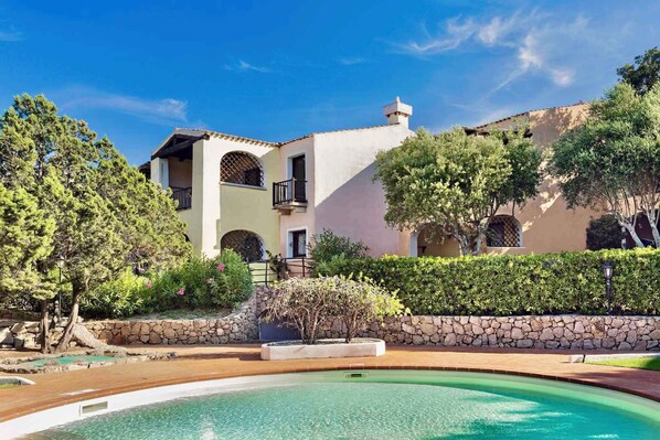 A Mediterranean-style villa with a swimming pool, stone walls, and lush greenery. - Holiday apartment mit Klimaanlage und Pool (Liscia di Vacca)