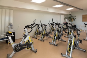 A gym with multiple stationary bikes arranged in rows. - Apartment in Guidel by the Seafront (Guidel)