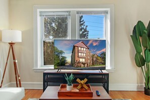 Apartamento luxo, 1 quarto | Área de estar | TV de tela plana 55 polegadas com canais digitais, TV, Netflix