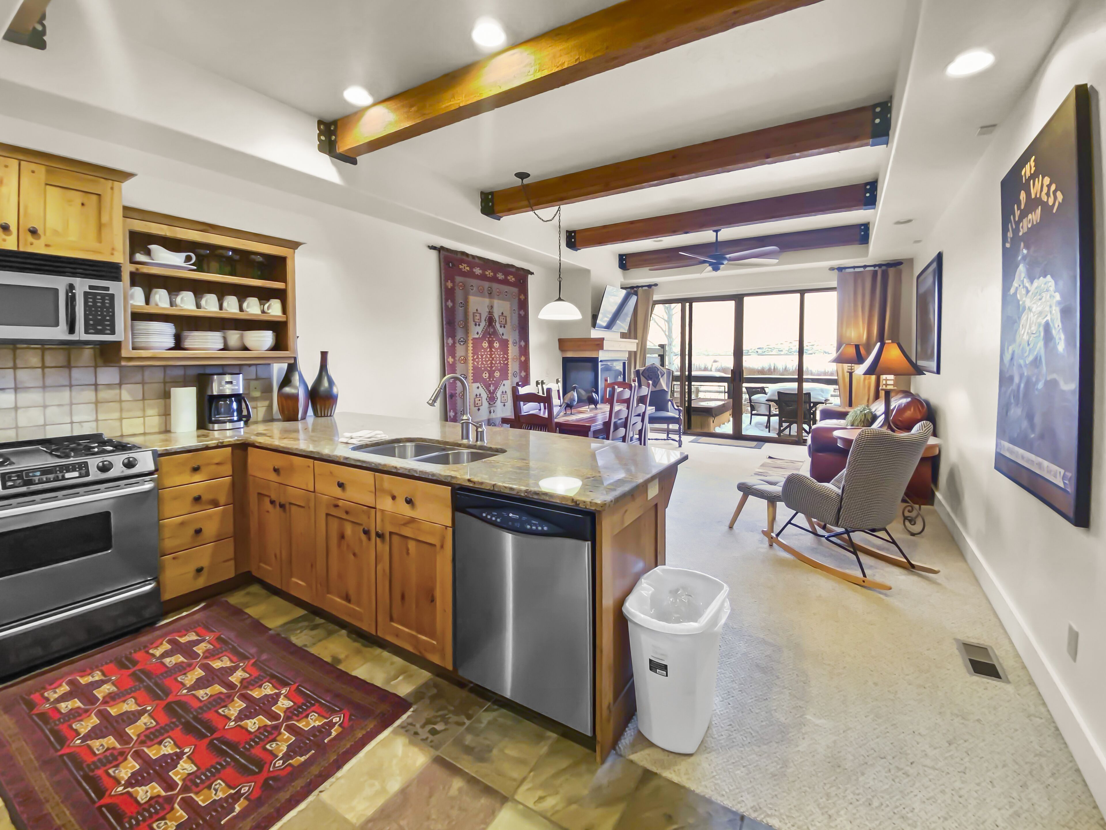 A spacious kitchen with wooden cabinets, a large island, and a dining area with a view.