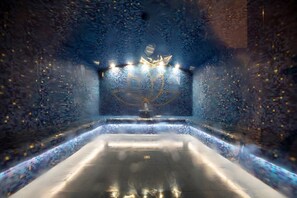 A room with a reflective floor, a central light fixture, and walls covered in small, square tiles. - Cozy Suite on the Slopes (Bourg-Saint-Maurice)