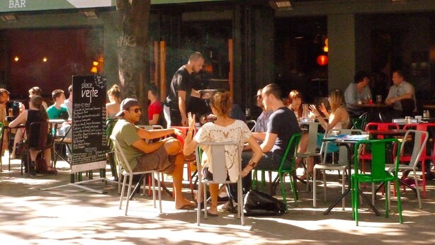 An outdoor cafe with tables and chairs, a menu board, and a bar in the background. - Villa with garden near beautiful golf course (Vasles)