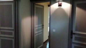 A hallway with closed doors and a light fixture above one door. - Holiday Home in Quend-Plage near Forest (Quend-Plage)