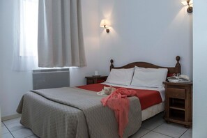 A bedroom with a bed, a bedside table, a nightstand, a window with curtains, and a wall-mounted lamp. - Apartment in Bergheim near Alsace Vineyards (Bergheim)