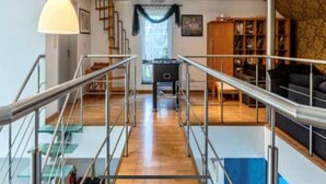A spacious living area with a staircase, a large window with curtains, and a bookshelf. - House in Moulin du Ruy with Forest Views (Stoumont-Moulin du ruy)