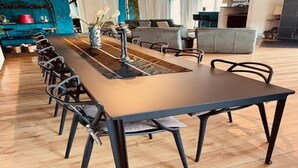 A modern dining area with a long table, chairs, and a decorative centerpiece. - House in Moulin du Ruy with Forest Views (Stoumont-Moulin du ruy)