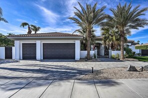A modern house with a garage, palm trees, and a well-maintained driveway. - Private Pool & Spa: Spacious Home in Bermuda Dunes (Bermuda Dunes)