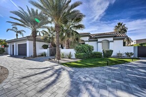 A modern house with a paved driveway, palm trees, and a well-maintained lawn. - Private Pool & Spa: Spacious Home in Bermuda Dunes (Bermuda Dunes)