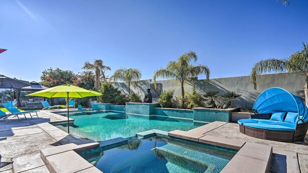 A swimming pool with clear water, surrounded by lounge chairs and a sun umbrella. - Private Pool & Spa: Spacious Home in Bermuda Dunes (Bermuda Dunes)