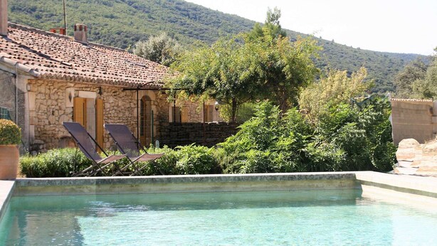 A stone building with a tiled roof, a swimming pool, and lounge chairs. - Holiday Home in Lacoste with Pool (Lacoste)