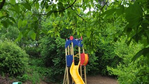A playground with a slide and a bench. - Villa Apartment with Terrace (Durbuy)
