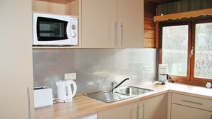 A kitchen with a microwave, toaster, coffee maker, and a sink.