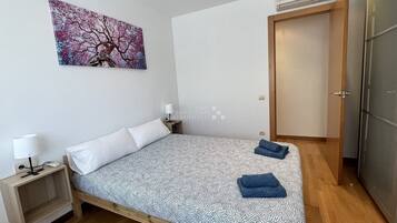Cozy retreat with a single bed, bedside table, and wall-mounted air conditioning unit.