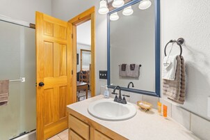 Un bagno con una porta in legno, un lavandino bianco, uno specchio e un porta asciugamani.