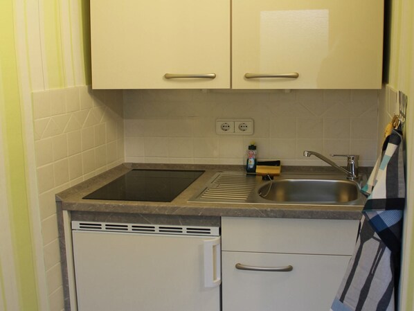 Una cocina compacta con dos encimeras, un lavabo y un lavavajillas.