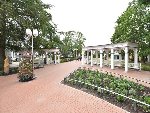 Ein Park mit einem Pavillon, Bänken und Blumenbeeten.