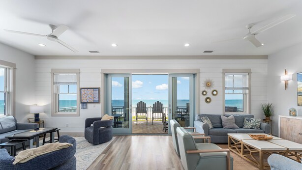 A spacious living area with a view to the outdoors, a balcony with outdoor furniture, and a large window with blinds. - All open summer weeks just discounted up to 25%! Book now for lowest rates of th (Cape San Blas)