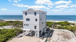 A multi-story building with a flat roof, located near a beach with a clear view of the ocean. - All open summer weeks just discounted up to 25%! Book now for lowest rates of th (Cape San Blas)
