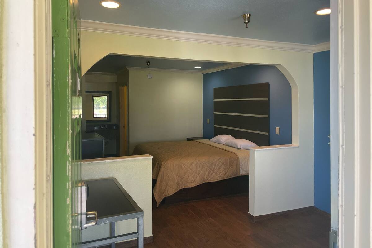 Un dormitorio con cama, escritorio y ventana.