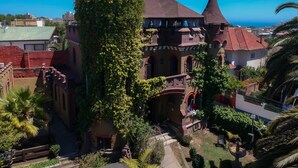 Un edificio histórico con una torre, muros cubiertos de hiedra y un patio.