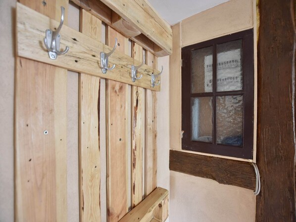 A wooden wall with a window and a wooden bench with hooks. - Wohnung in Groß Strömkendorf (Groß Strömkendorf)